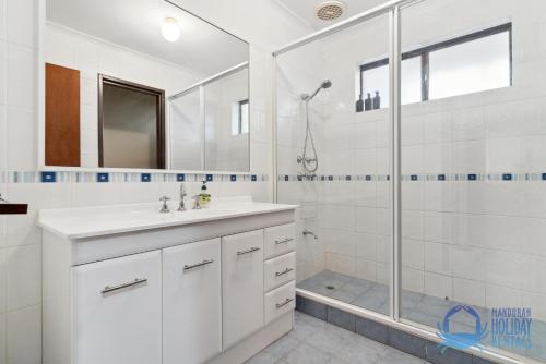 La salle de bains blanche est pourvue d'un lavabo et d'une douche. dans l'établissement Drop your Anchor in Yunderup, à South Yunderup