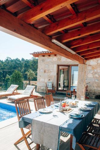 a blue table with chairs on a patio with a pool at Just Like Home - Muirfield House em Caminha in Caminha