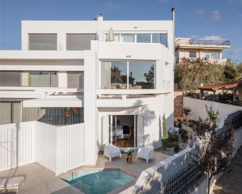 una casa blanca con piscina frente a ella en Athenian Riviera Panorama Villa en Athens