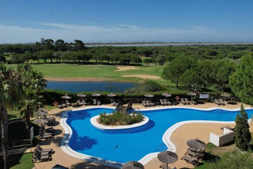 - une vue sur la piscine du complexe dotée de chaises et de parasols dans l'établissement Precise Resort El Rompido-The Club, à El Rompido
