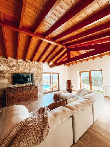 a living room with a large couch and a tv at Just Like Home - Muirfield House em Caminha in Caminha