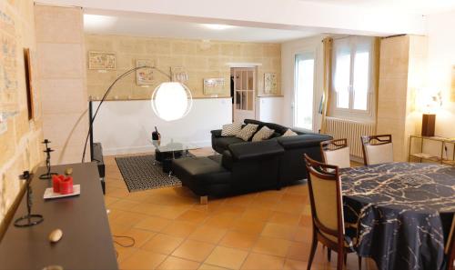 a living room with a couch and a table at Pomerol au Cœur in Pomerol