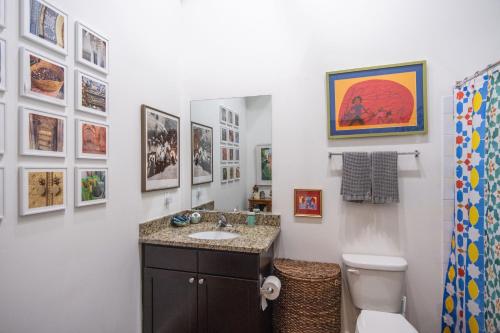a bathroom with a sink and a toilet and pictures on the wall at Elegant Downtown Memphis Loft - Walk to Beale St! in Memphis