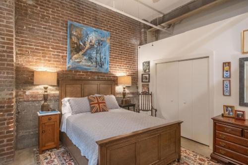 a bedroom with a bed and a brick wall at Elegant Downtown Memphis Loft - Walk to Beale St! in Memphis