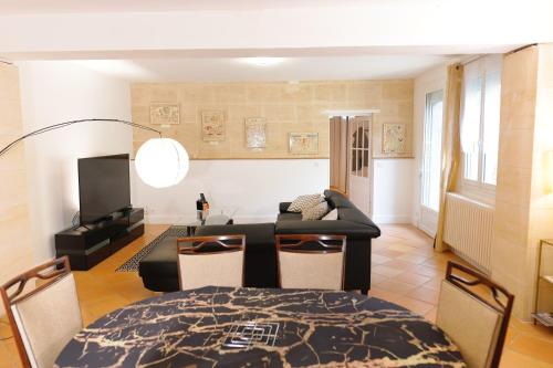 a living room with a table and a couch at Pomerol au Cœur in Pomerol