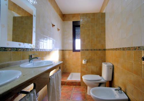 コニル・デ・ラ・フロンテーラにあるVillas Rocío ConiLのバスルーム(洗面台2台、トイレ、鏡付)