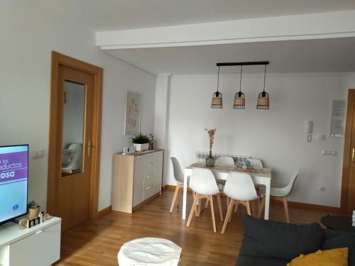 een woonkamer met een tafel en witte stoelen bij Coqueto apartamento en urbanización piscina y golf in Cirueña