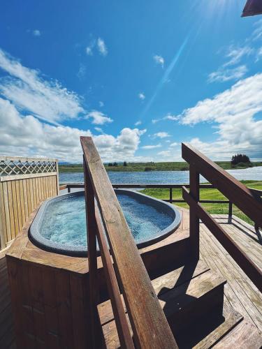 a hot tub on a deck next to a fence at West Ranga lodge in Hella