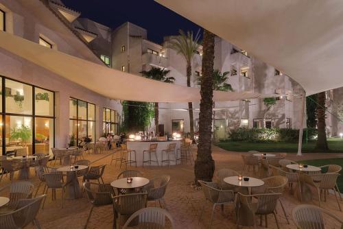 a restaurant with tables and chairs in a courtyard at night at Precise Resort El Rompido-The Club in El Rompido