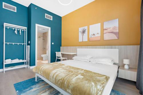 a bedroom with a bed and a blue and yellow wall at Exclusive Dubai Marina Two Bedroom Suite by Jumeirah Beach, Mall and Metro in Dubai