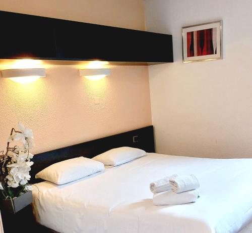 two towels on a bed in a hotel room at Hôtel du Parc Limoges & Restaurant "Le temps d'une pause" in Limoges