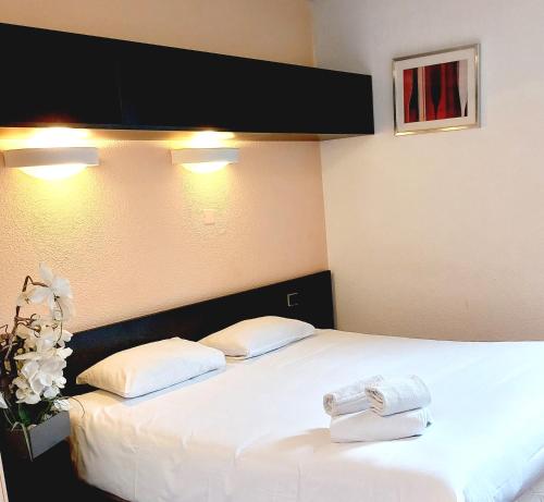 - 2 serviettes sur un lit dans une chambre d'hôtel dans l'établissement Hôtel du Parc Limoges & Restaurant "Le temps d'une pause", à Limoges