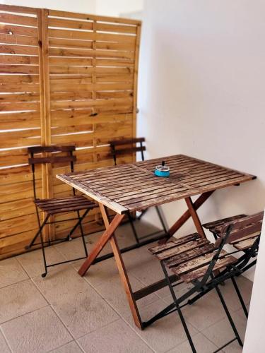 une table en bois avec deux chaises et un mur en bois dans l'établissement Proche Stade Toulousain - Blagnac - Parking, à Toulouse