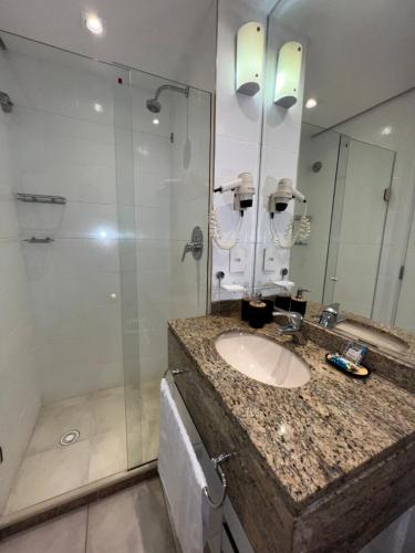 a bathroom with a sink and a shower at HOTEL PERDIZES - FLAT Executivo - 504 in São Paulo