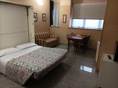 ein Hotelzimmer mit einem Bett, einem Tisch und Stühlen in der Unterkunft Residence Le Arcate in Gavirate