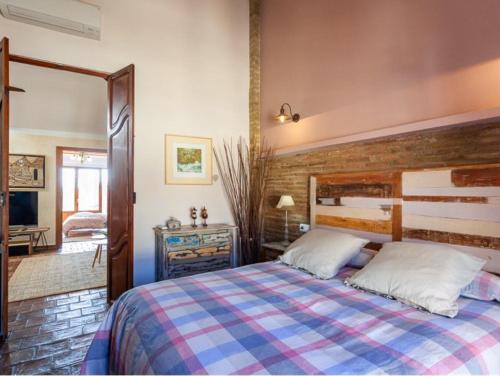 a bedroom with a large bed with a wooden headboard at La Isla del Júcar in Barraca de Aguas Vivas
