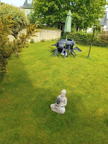 una estatua sentada en el césped en un patio en Gîte les palmiers, en Guingamp