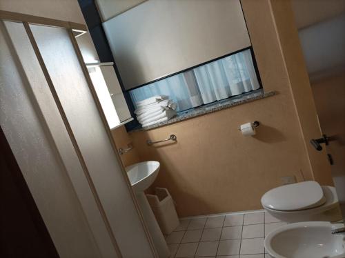 a bathroom with a toilet and a sink and a mirror at Residence Le Arcate in Gavirate