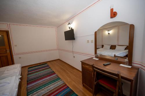 a bedroom with a mirror and a desk and a bed at Недкова къща in Koprivshtitsa