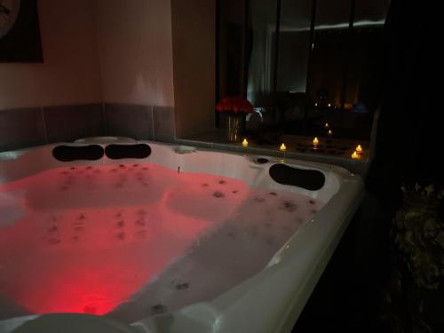 a white bath tub with red lights in it at Just'un Instant in Landrecies