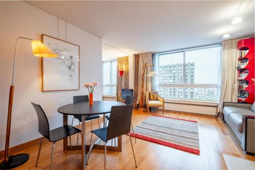 un salon avec une table, des chaises et un canapé dans l'établissement Veeve - Eiffel Skies, à Paris