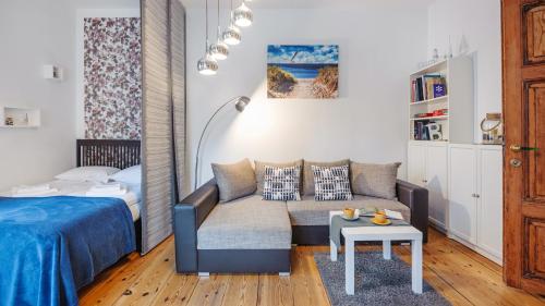 a living room with a couch and a bed at Apartamenty Sun & Snow Obrońców Westerplatte 8 in Sopot
