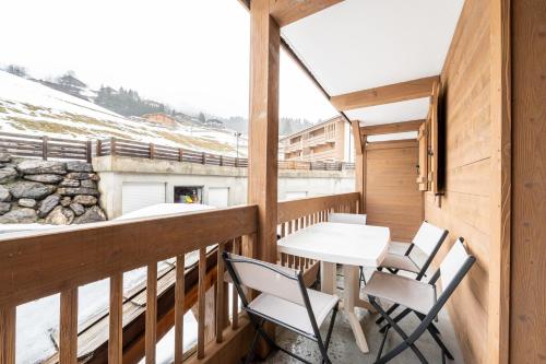 un balcon avec une table et des chaises dessus dans l'établissement Le Chemin des Alpages - Vue montagne, à La Giettaz