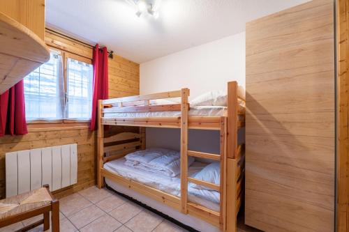 a bedroom with two bunk beds in a cabin at Le Chemin des Alpages - Vue montagne in La Giettaz