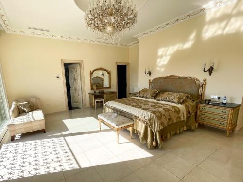 ein großes Schlafzimmer mit einem Bett und einem Kronleuchter in der Unterkunft Exklusive Villa in Paguera für bis zu 8 Personen, mit Meerblick und Pool in Peguera