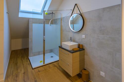 La salle de bains est pourvue d'une douche et d'un miroir mural. dans l'établissement L’Innamoramento - Charmant appt pour 4, à Solesmes
