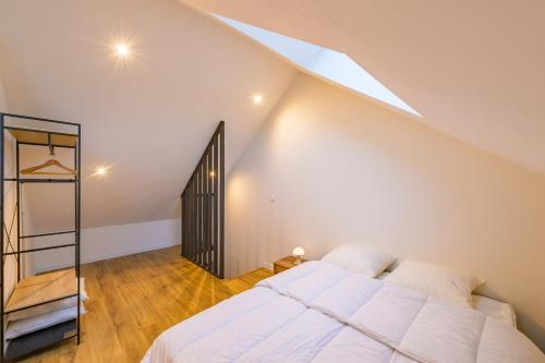 - une chambre avec un lit blanc et un escalier dans l'établissement L’Innamoramento - Charmant appt pour 4, à Solesmes