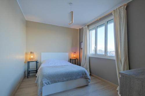 een slaapkamer met een bed en een groot raam bij Paquebot - Appt vue mer in Saint-Nazaire