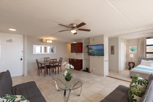 uma sala de estar com um sofá e uma ventoinha de tecto em Newly Remodeled Corner Unit at the Waikiki Banyan with Diamond Head Views condo em Honolulu