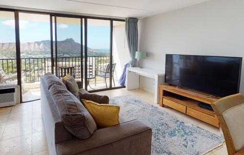 a living room with a flat screen tv and a couch at One-Bedroom Apartment in Honolulu