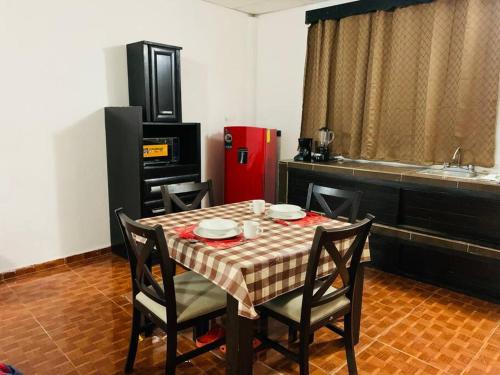 eine Küche mit einem Tisch und einem roten Kühlschrank in der Unterkunft Departamento en el centro, 2 recamaras, estacionam in Paraíso
