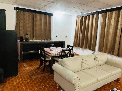 ein Wohnzimmer mit einem weißen Sofa und einem Tisch in der Unterkunft Departamento en el centro, 2 recamaras, estacionam in Paraíso