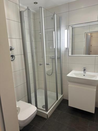 a bathroom with a shower and a toilet and a sink at Planke 18 in Norderney