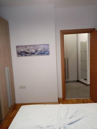 een slaapkamer met een bed, een spiegel en een deur bij Brand New, Modern & Cozy apartment in Central area in Skopje