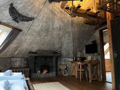 a bedroom with a fireplace and a table and a bed at Excalibur miniHotel in Eger