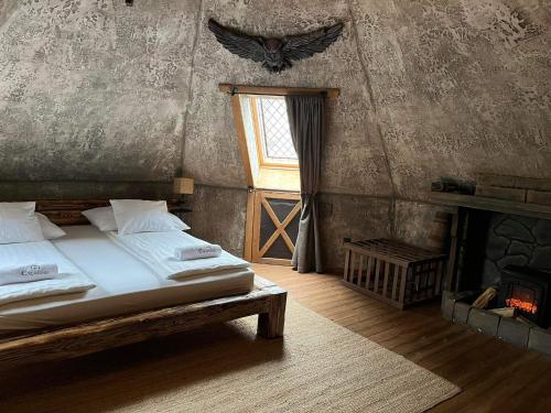 a bedroom with a bed and a window and a fireplace at Excalibur miniHotel in Eger