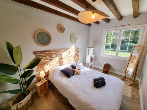 une chambre avec un grand lit avec un animal en peluche dessus dans l'établissement La Cabane Wave House - Maison cosy au calme proche lac, à Sainte-Eulalie-en-Born