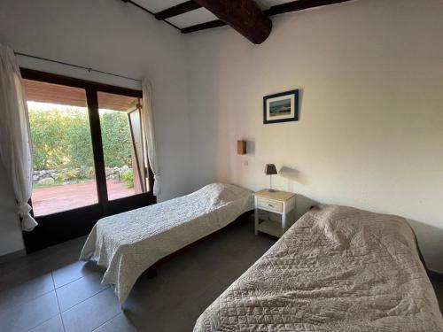 deux lits dans une chambre avec une fenêtre dans l'établissement Villa Alando, Santa Giulia, à Porto-Vecchio