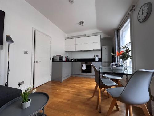 cocina y sala de estar con mesa y sillas en Apt 4, Soho Apartments 2nd floor by Indigo Flats, en Londres