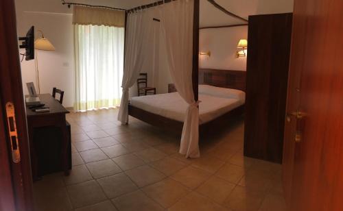 a bedroom with a bed with a canopy at Hotel Resort Poggio degli Ulivi in Rodi Garganico