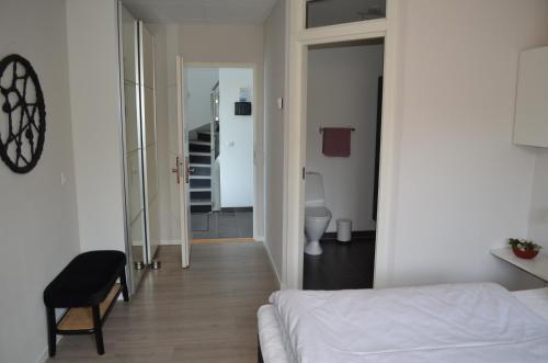 a bedroom with a bed and a hallway with a toilet at Naturperlen in Rødekro
