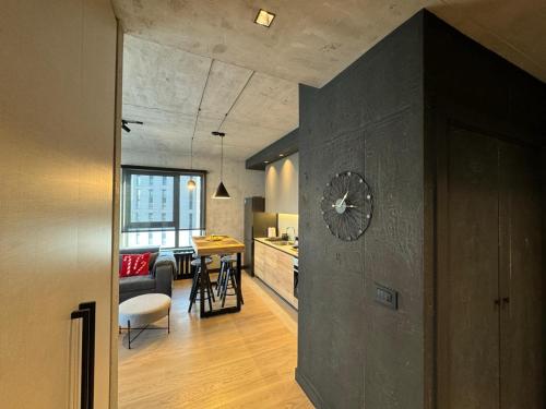 Una sala de estar y una cocina con un reloj en la pared. en Belgrade Waterfront Luxury Apartment, en Belgrado