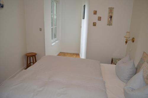 a white bed in a room with a window at Naturperlen in Rødekro