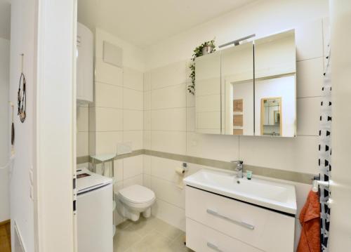a white bathroom with a toilet and a sink at New with Parking and Metro in front of the House in Vienna