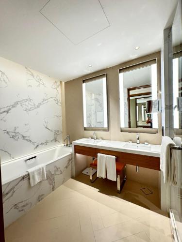 a bathroom with two sinks and a tub and a mirror at The address opera t1 burj khalifa in Dubai