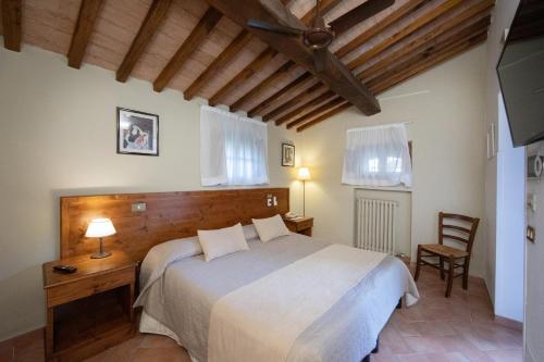 a bedroom with a bed and a desk and chairs at Tenuta Decimo - Il Borgo Di Mariano in San Gimignano